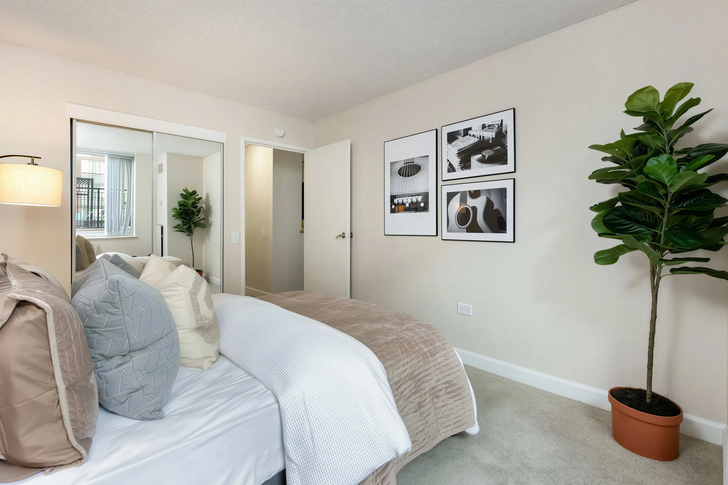 Comfortable apartment bedroom with mirrored closet and natural light in Uptown Denver
