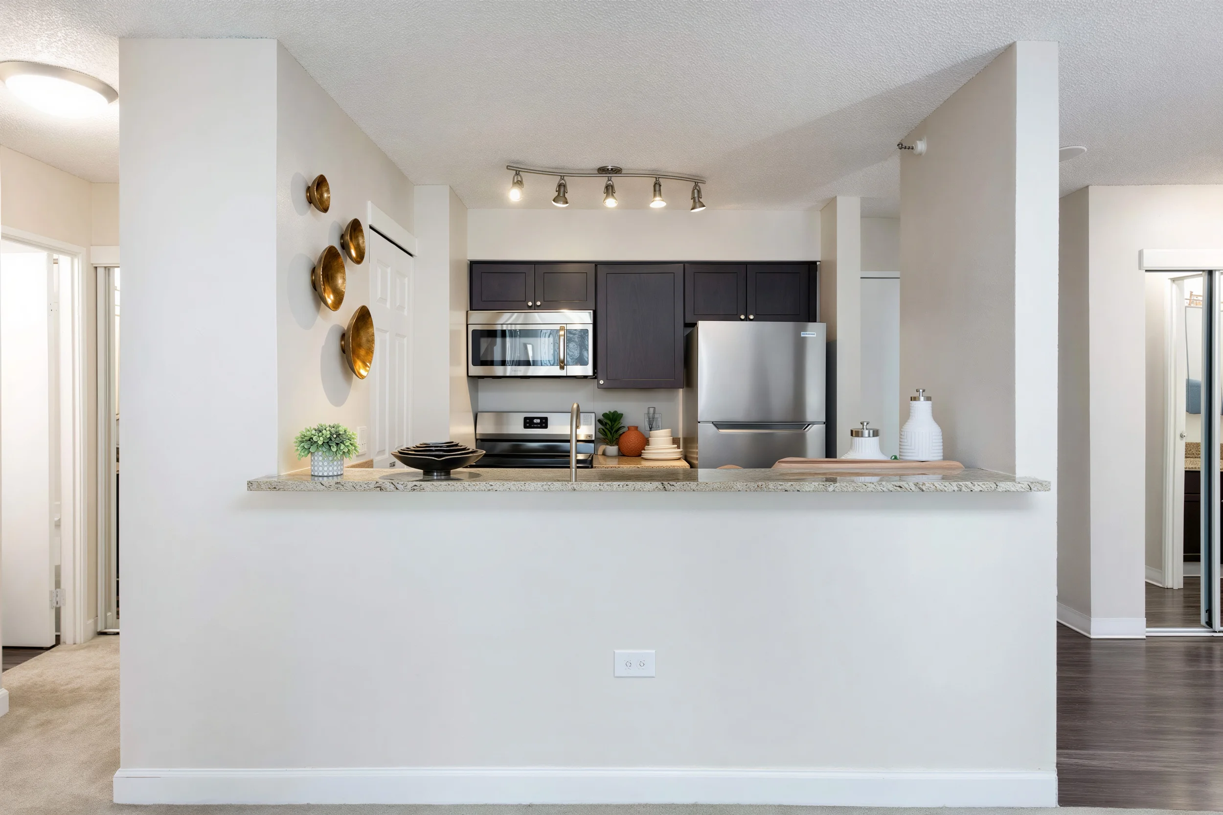 Apartment kitchen with breakfast bar, stainless steel appliances and granite countertops in Uptown Denver